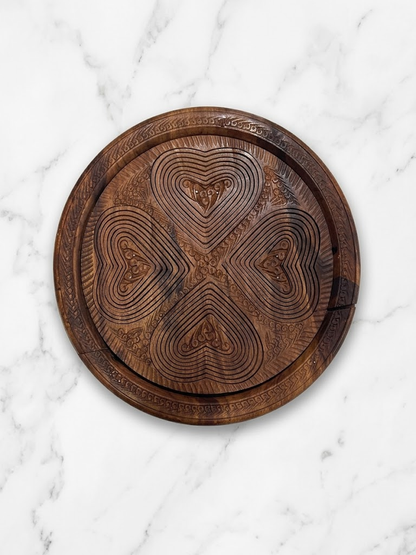 Bottom view of hand-carved wooden tray showing intricate heart pattern craftsmanship