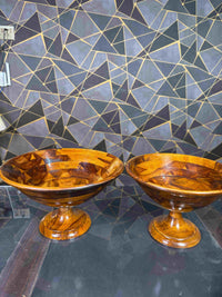 Two wooden serving bowls with pedestal stands displayed side by side